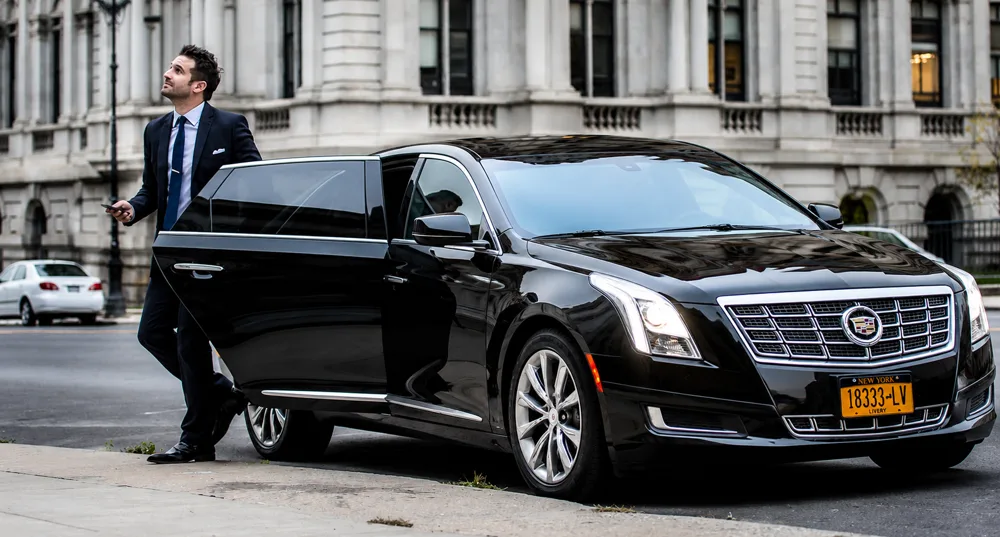 Professional chauffeur standing next to a sleek black SUV at Chicago O'Hare International Airport